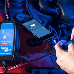 Victron Blue Smart charger displayed with smartphone app interface showing charging status and settings during operation.